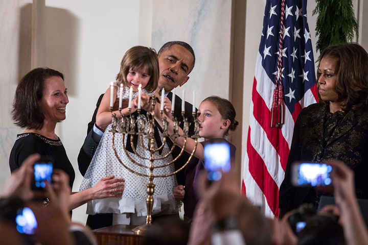 President Barak Obama and first Lady Michelle Obama with children lighting a Hanukkah menorah in the White House, Dec. 5, 2013. Official White House photo by Lawrence Jackson.