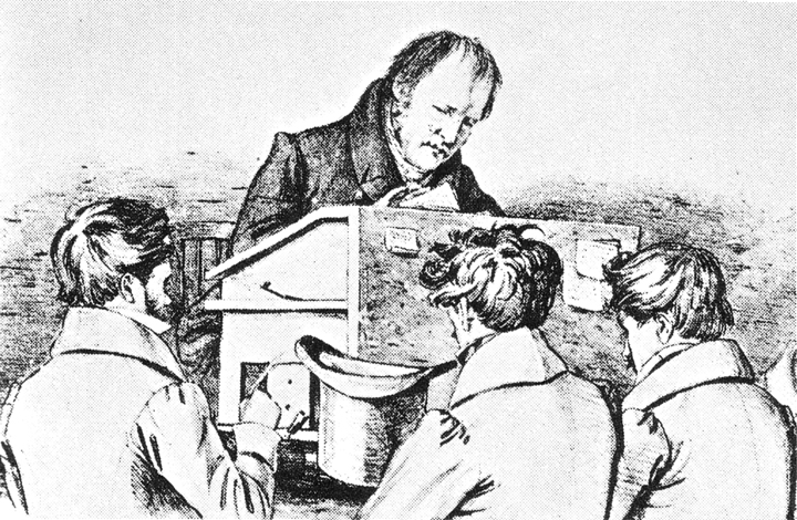 “Hegel am Katheder [Hegel teaching his pupils],” lithograph, 1828 by F. Kluger. Schiller Nationalmuseum Marbach am Neckar; via Wikimedia Commons.